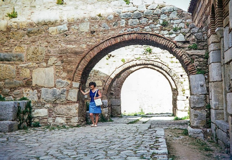 Female tourist standing under arches at Byzantine Monastery of Hosios Loukas Osios Loukas, Boeotia region, Distomo, Central Greece, Europe 1972