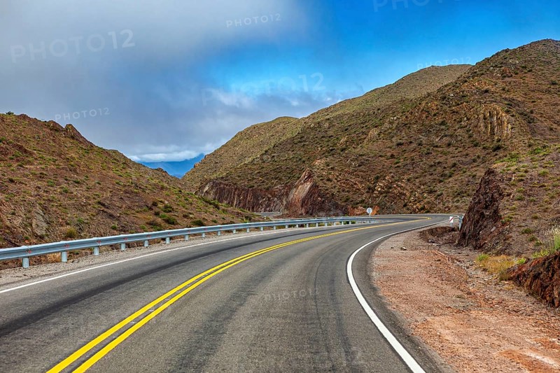 Curvy road through a dry, mountainous landscape, blue sky, roads through the Quebrada de Cafayate countryside near Salta in Argentina