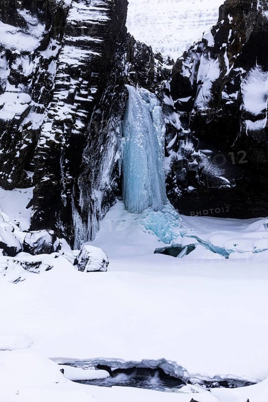 Frozen waterfall, Folaldafoss, snowy rock face, Sudausturland, Iceland