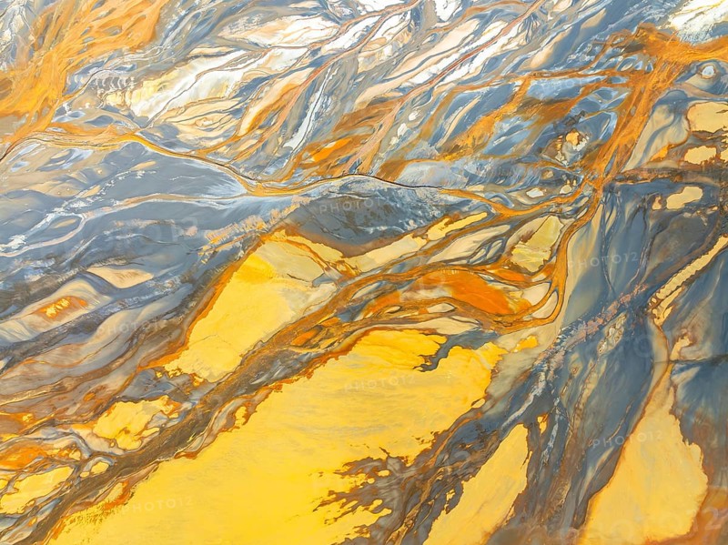 Top view of striking abstract nature textures captured by a drone, showcasing vivid colors and fluid patterns