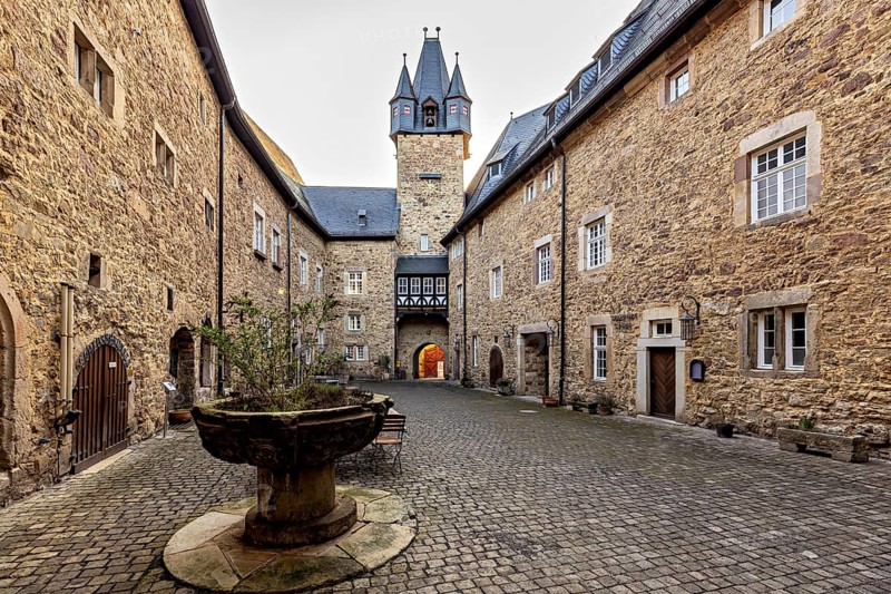 A courtyard steeped in history with stone walls, a tower and charming old buildings: the courtyard of Spangenberg Castle