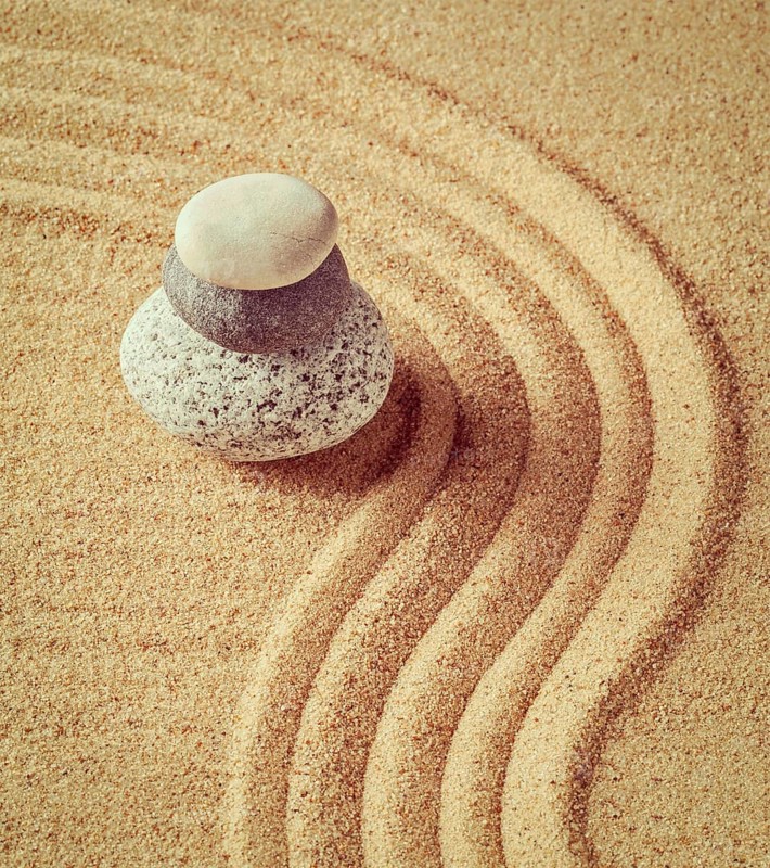 Vintage retro effect filtered hipster style image of Japanese Zen stone garden, relaxation, meditation, simplicity and balance concept, pebbles and raked sand tranquil calm scene