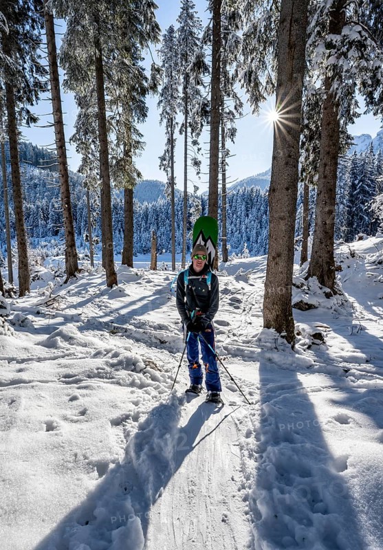 Snowshoe hiker in snowy winter forest, Sonnenstern, Ascent to Teufelstättkopf, Snowy mountain landscape, Ammergau Alps, Bavaria, Germany