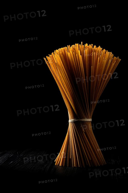 Low key photo of whole wheat semolina pasta rich in fiber. Organic linguine