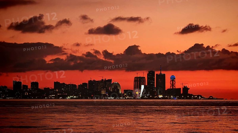 City view at sunset with illuminated buildings and a waterway in the foreground, Batumi, Georgia