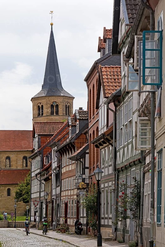 Facades of half-timbered houses in Brühlstrasse with the steeple of the Basilica of St. Godehard, Hildesheim, Lower Saxony, Germany