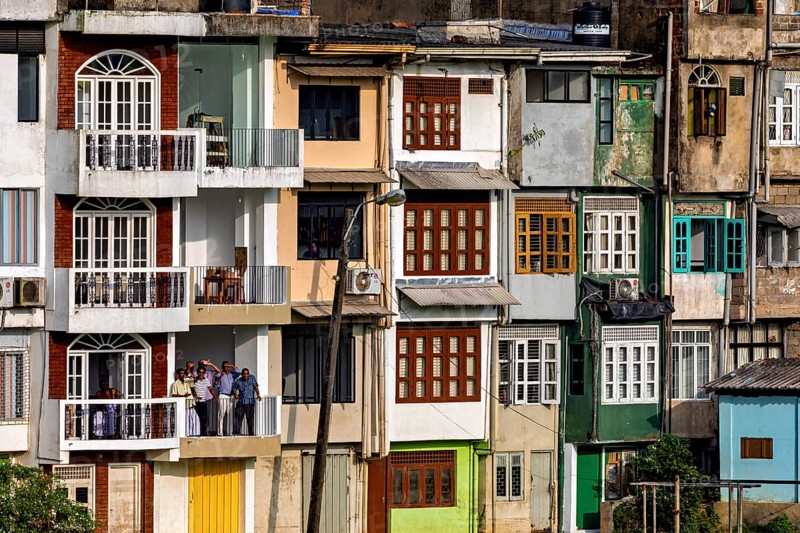 Multi-storey building with colorful facades and several balconies in an urban setting, A house façade in Ratnapura in Sri Lanka