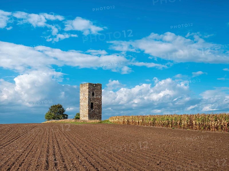 The Blue Tower in a ploughed field in autumn, medieval watchtower in the Magdeburger Börde, blue sky with dramatic clouds, Wanzleben-Börde, Saxony-Anhalt, Germany