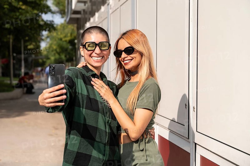A Colombian lesbian couple joyfully takes a selfie outdoors. Showcasing love, diversity, and LGBTQIA+ pride, they embody identity, respect, and the celebration of love