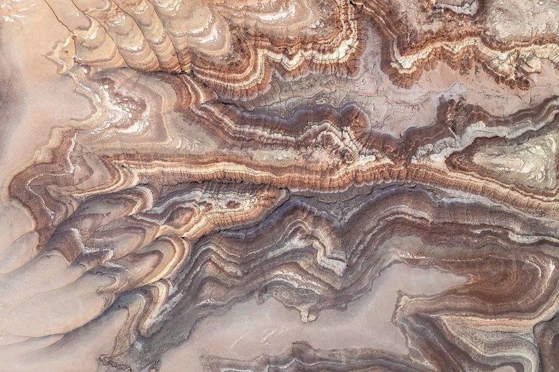 Aerial shot capturing the intricate patterns of bentonite sandstone in Utah, USA. The natural swirls and earthy tones create a mesmerizing and textured landscape