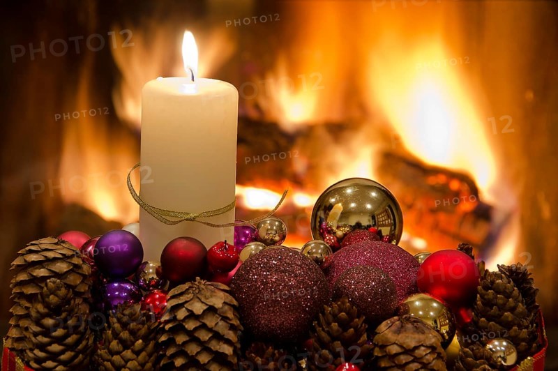Christmas floral table decoration in front of the fireplace with candles