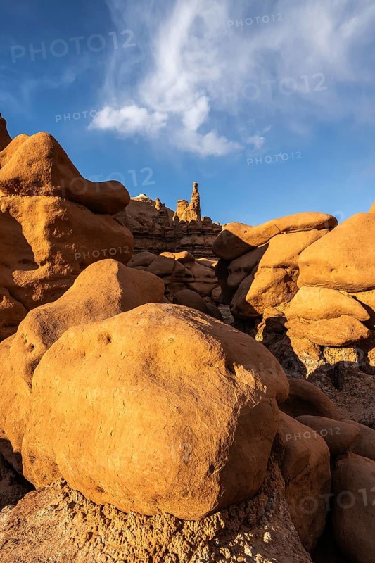 Sandstone formations in Goblin Valley State Park, Utah, create an otherworldly landscape. The golden hues and unique textures stand out sharply against the deep blue sky