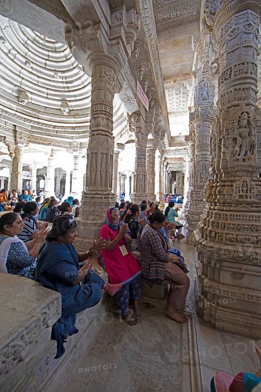 Indian woman praying between the white marble pillars in the Adinath temple in Ranakpur, Jain temple, Rajasthan, India