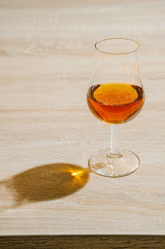 Glass of cognac on a table in a bright sunny day