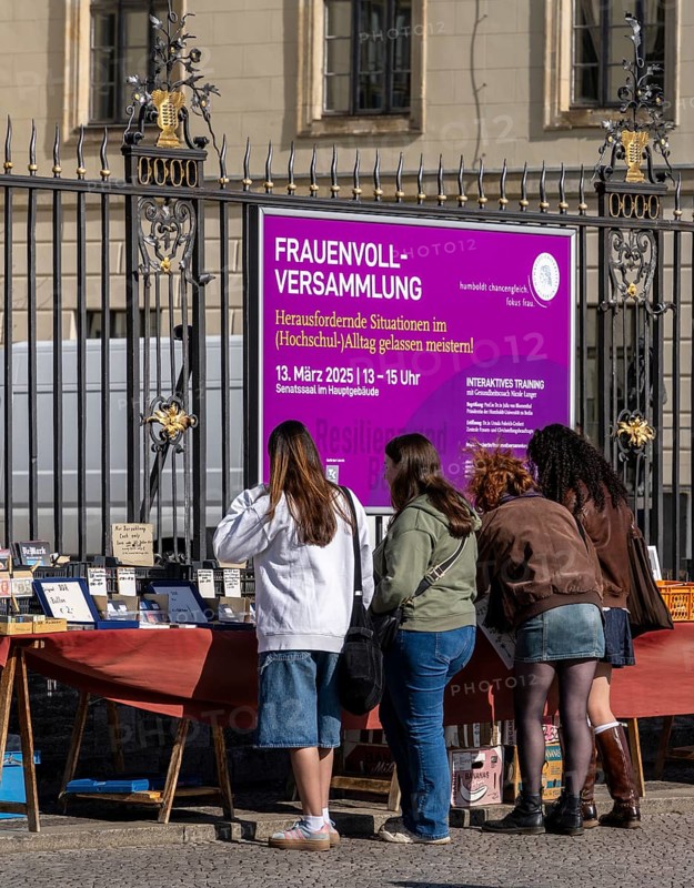 Tourists browse the book flea market in front of the entrance to Humboldt University, Unter den Linden, Berlin
