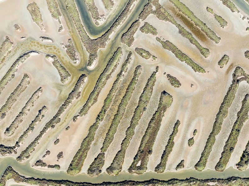 Saline ponds at the salt works near Chiclana de la Frontera. Aerial view. Drone shot. Bahía de Cádiz Nature Reserve, Cádiz province, Andalusia, Spain