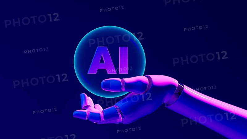 A robotic hand grips a glowing bubble with AI against a dark backdrop, symbolizing progress in artificial intelligence