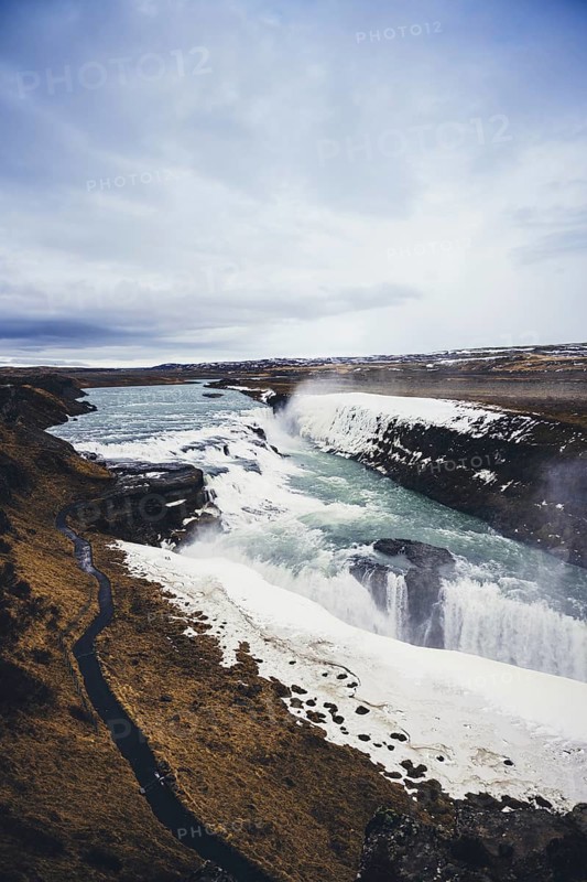 A breathtaking beauty of Gullfoss Waterfall in Iceland. The powerful cascade flows over rugged cliffs, surrounded by stunning icy landscapes and dynamic skies