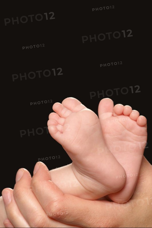 A hand holding the feet of a baby, Hamburg, Federal Republic of Germany