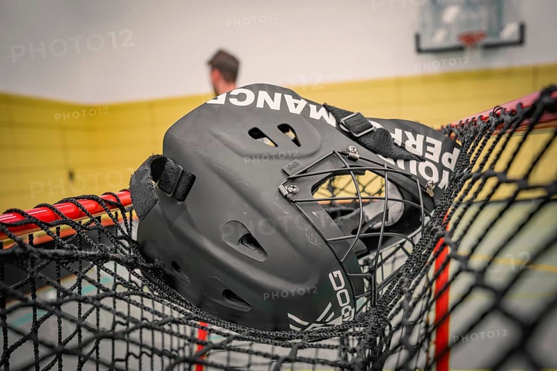 Black floorball helmet is lying on the net of a goal in a sports hall, Foolball, Calw, Germany