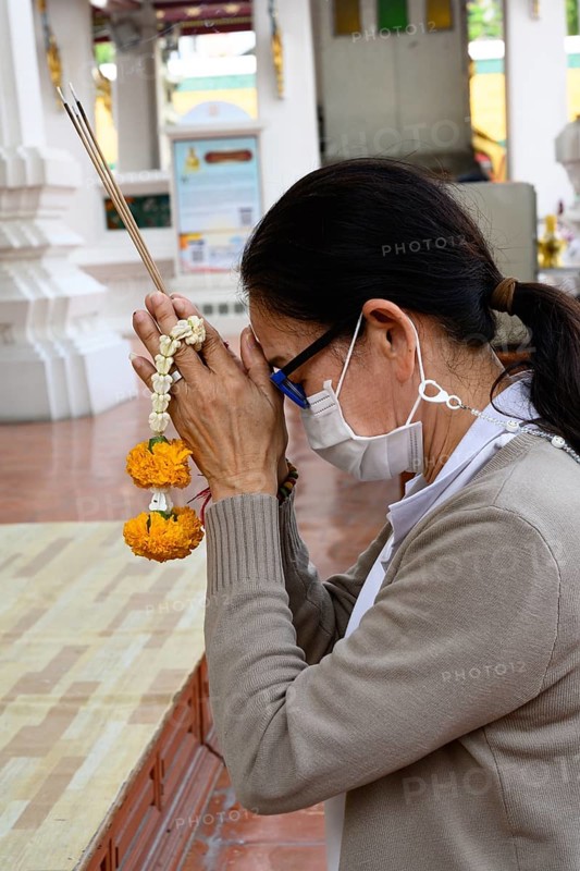 Bangkok, Thailand. February 20th 2025. A Thai visitor prays and makes an offering at The Wat Suthat Thepwararam Temple, Bangkok