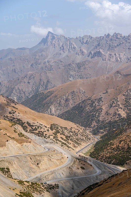 Winding roads on the Pamir Highway, mountain road through an eroded mountain landscape, Kyrgyzstan