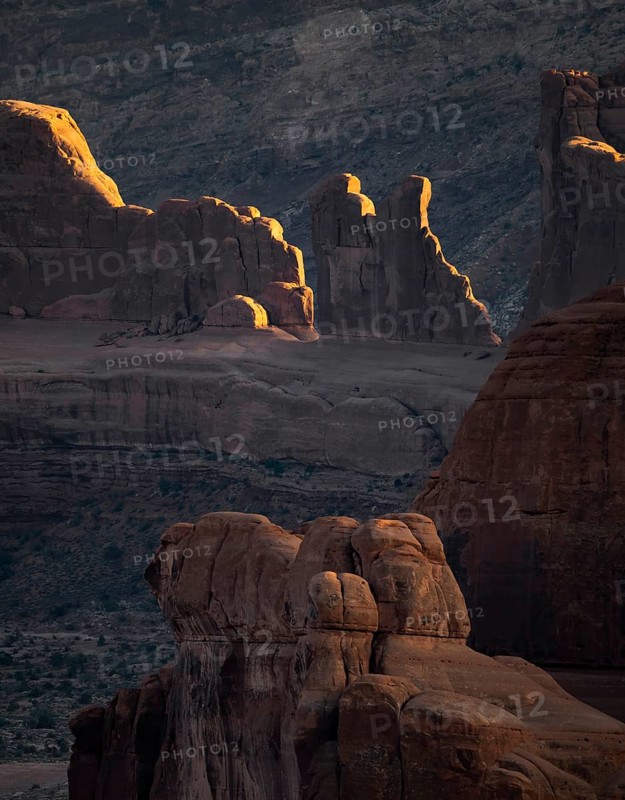 Stunning sandstone formations in Arches national park, USA, illuminated by the setting sun. This captivating landscape showcases nature's intricate artistry set against a dramatic backdrop