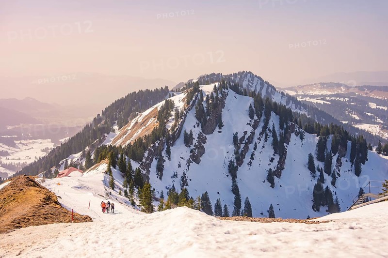 Hikers climb snow-capped mountain with breathtaking views, Hochgrat Mountains, Allgäu Alps, Oberreute, Germany