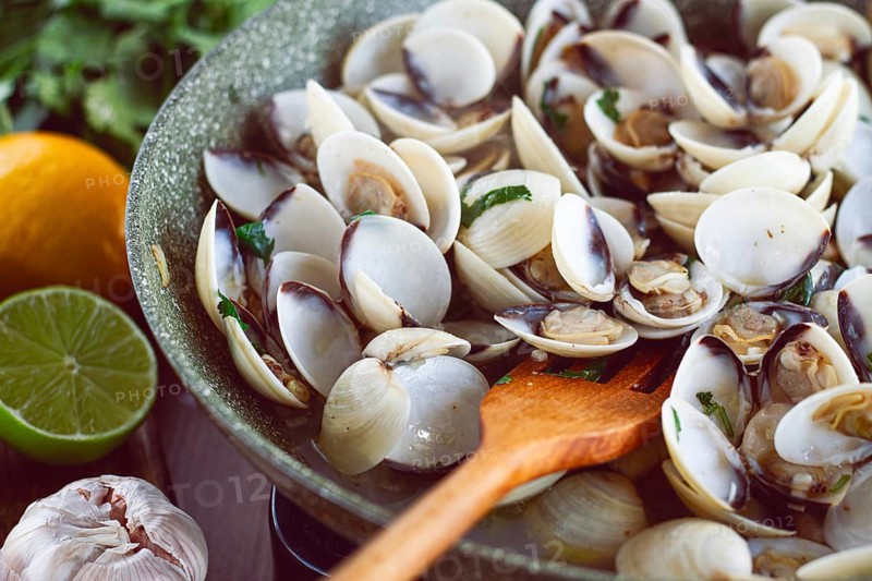 Cooking, vongole clams, in a pan with spices and white wine, top view, no people