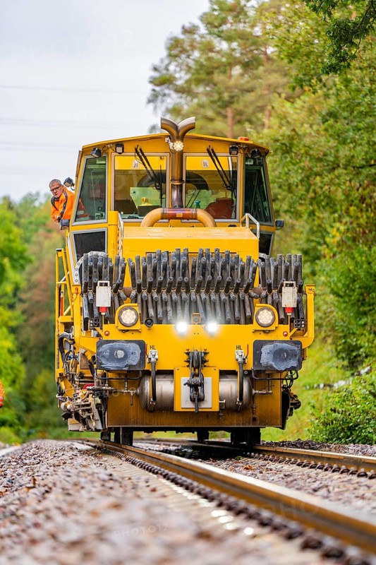 Railway working machine on tracks with workers standing around, track construction Hermann Hesse Bahn, district of Calw, Black Forest, Germany