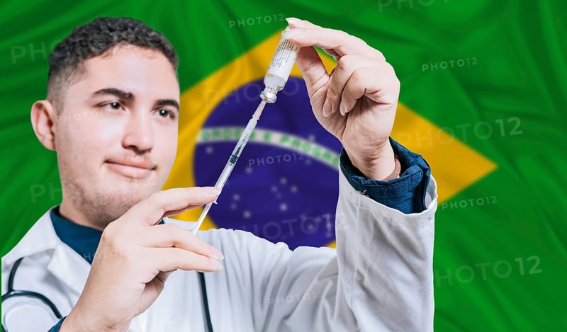 Doctor holding syringe on Brazil flag background. Medical professional holding syringe with Brazilian flag in the background