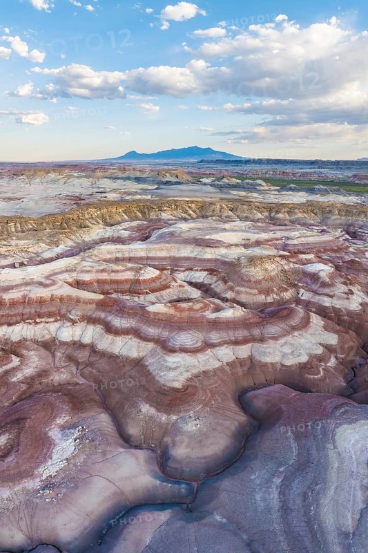Stunning aerial shot captures the rich, multi-colored bentonite landscapes of Utah, showcasing the remarkable undulating patterns and rugged beauty typical of the region