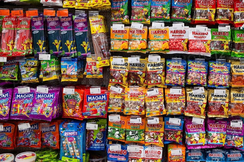 LUBIN, POLAND - JANUARY 15, 2026: Shelves in a supermarket filled with various colorful Haribo and Maoam gummy candies and sweets in plastic packaging