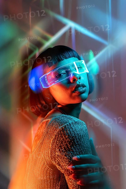 Latin woman engages in a futuristic experience using virtual reality glasses. Surrounded by vibrant neon light streaks, she immerses herself in a digital realm with curiosity