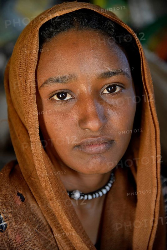 Young girl from a nomadic tribe, wearing headgear, portrait, Bayuda Desert, in Karima, Nubia, Northern Sudan, Sudan