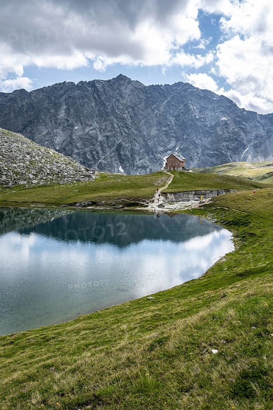 Rocky mountain peaks of the Panargenkamm and mountain hut Neue Reichenberger Hütte with mountain lake Bödensee, Lasörlinggruppe, Hohe Tauern National Park, East Tyrol, Austria