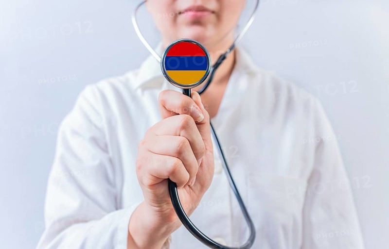 Female doctor holding stethoscope with Armenia flag. National health system of Armenia