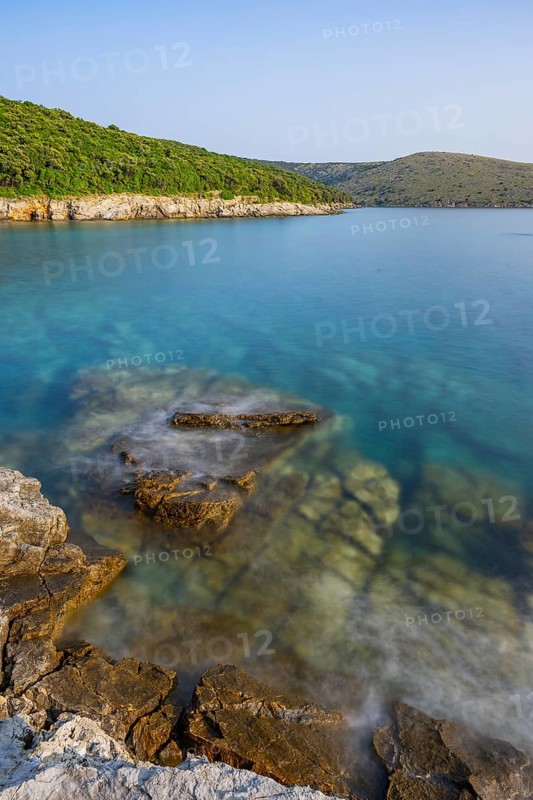 Crystal clear and turquoise water on the beach of Ustrine Bay on a sunny day on the island of Cres, long exposure, Croatia