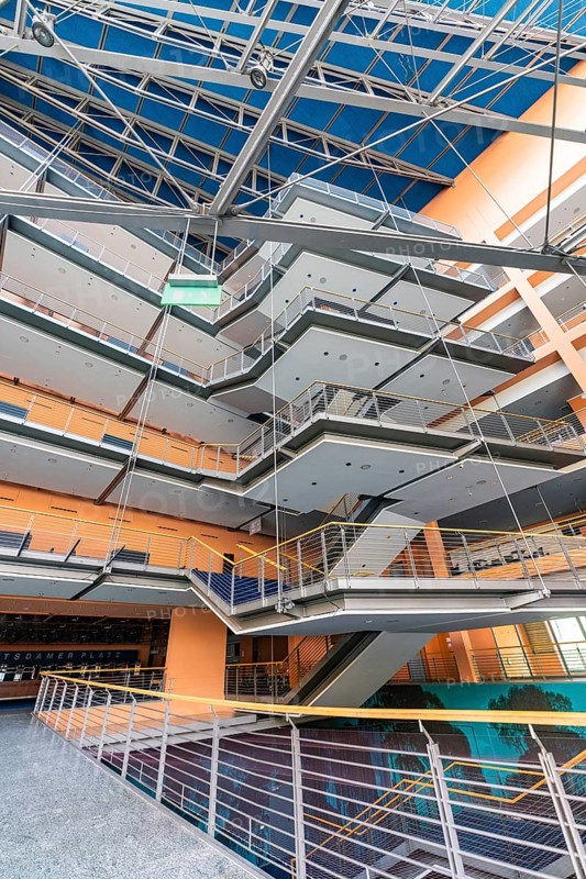 A modern office building with open spaces, glass facades and stairs, designed in bright colours, Berlin, Germany