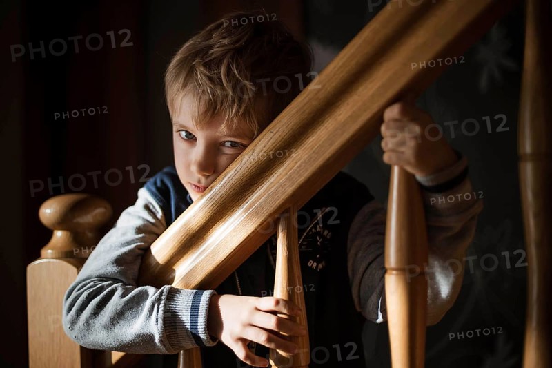 Bored boy by the railing on the stairs