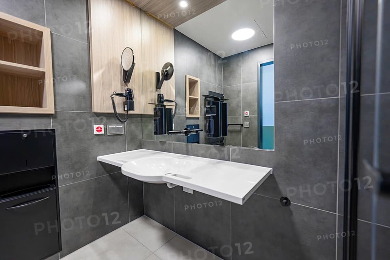Modern bathroom with tiles, large mirror and a white sink, optional patient room in the new hospital, Calw, Germany