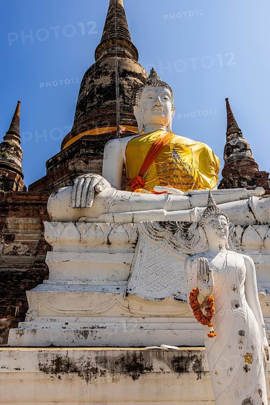 Stone Buddha statue decorated with yellow cloth, historic Buddhist temple complex, Ayutthaya, Thailand