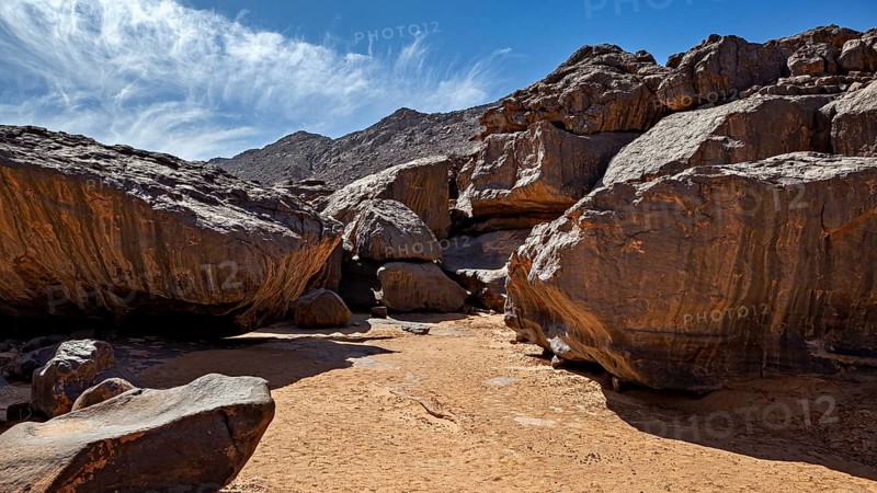 Massive rocks in a sunny desert landscape under a clear blue sky, rocky landscape in the Sahara in Algeria