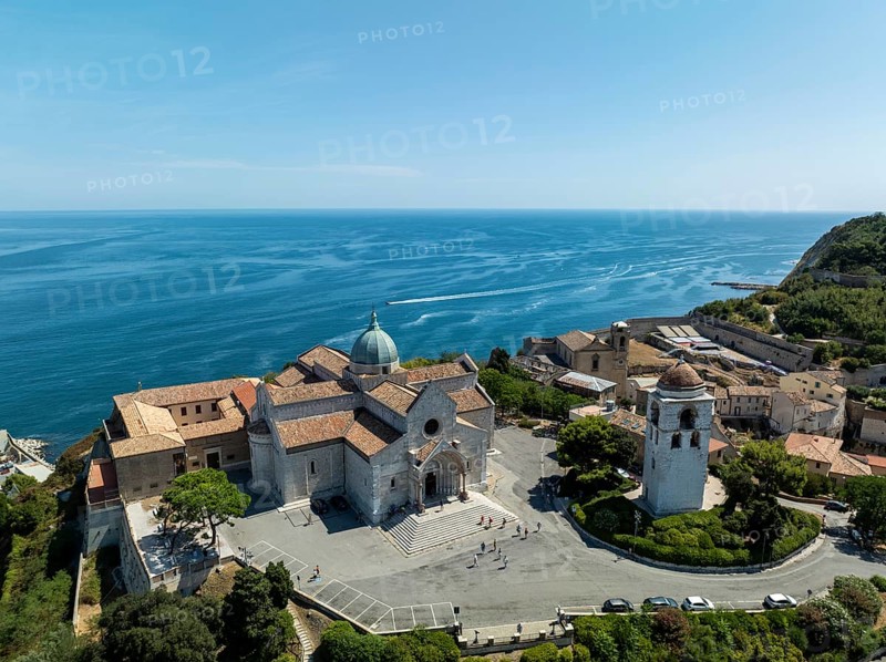 A stunning aerial view of a historic church near Ancona, Italy, overlooking the pristine Adriatic Sea. The composition highlights the beautiful architecture and serene coastal landscape