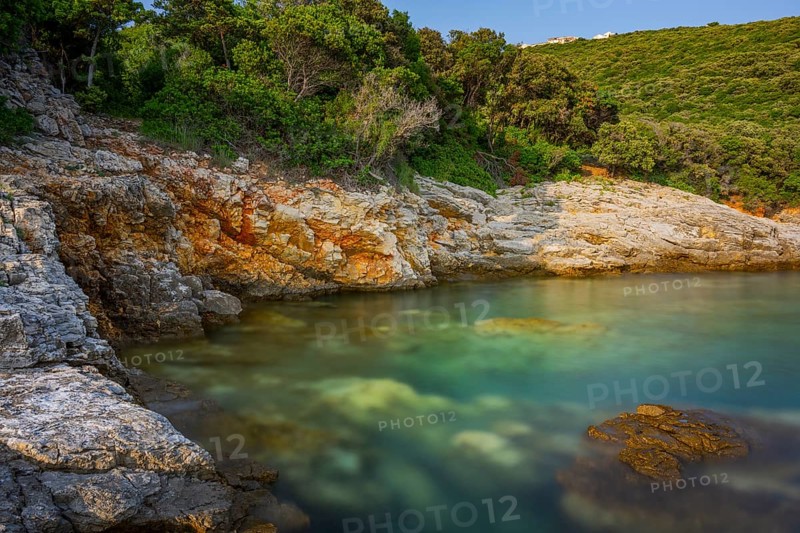 Crystal clear and turquoise water on the beach of Ustrine Bay on a sunny day at sunset on the island of Cres, long exposure, Croatia