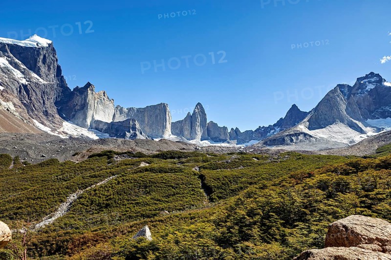 Majestic mountains with glaciers under clear skies and green vegetation, the landscape of Torres del Paine National Park in Patagonia Chile