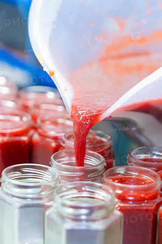 Liquid strawberry mass is filled from a cup into jars, jam production, Haselstaller Hof, Wildberg Gültlingen, district of Calw, Black Forest, Germany