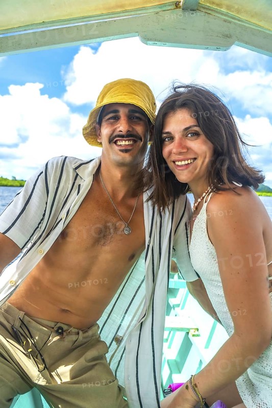 Happy couple smiling during a boat trip in siargao island, philippines, enjoying summer holidays