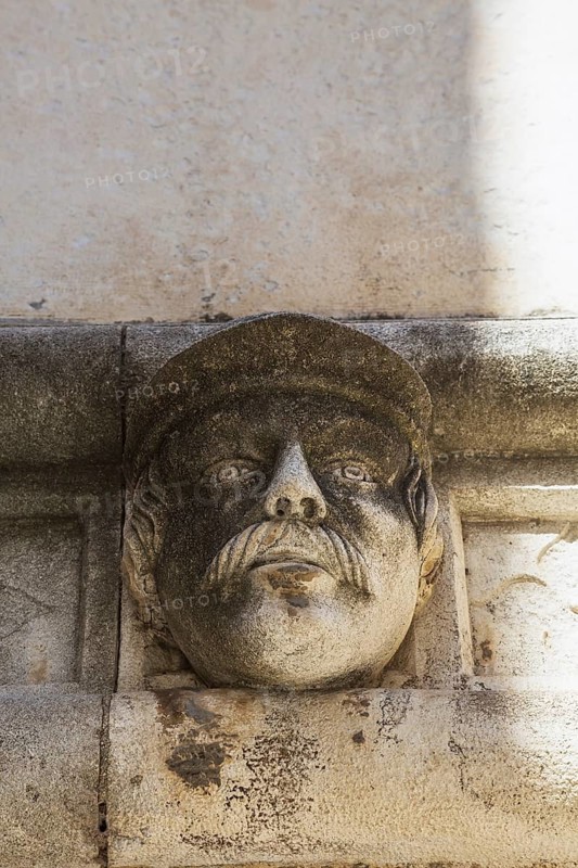 Sculpted face and carved architectural details on outside wall of The Cathedral of Saint James, Sibenik, Croatia