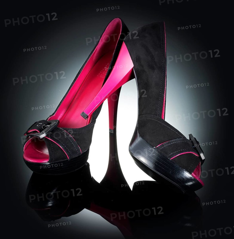 1 pair of shoes, women's shoes, in front of a black background with spot lighting, studio shot